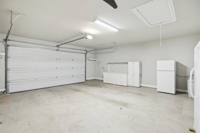 garage with freestanding refrigerator and a garage door opener