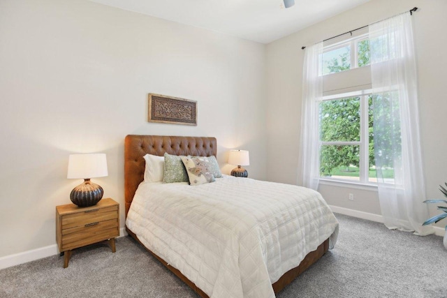 carpeted bedroom featuring multiple windows and baseboards