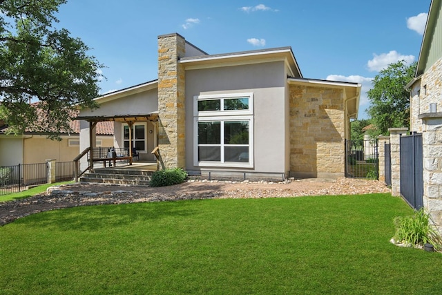 back of house with fence, a yard, stucco siding, and stone siding