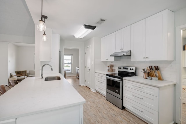 402 San Gabriel Blvd, Georgetown, TX 78628 - kitchen with stainless steel range with electric cooktop, under cabinet range hood, a sink, decorative backsplash, and light countertops