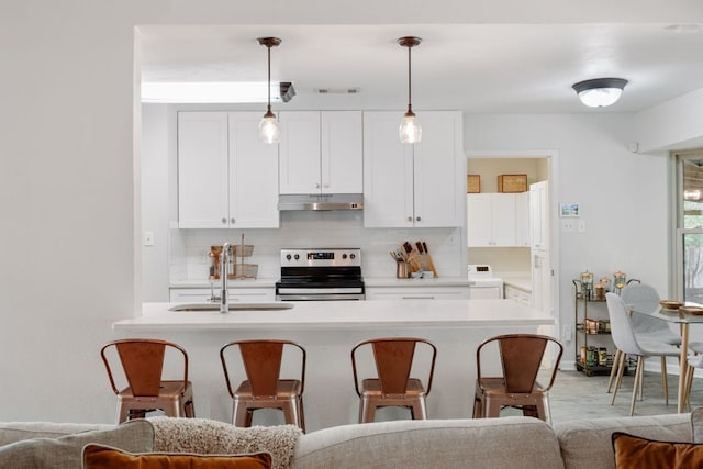 402 San Gabriel Blvd, Georgetown, TX 78628 - kitchen featuring stainless steel range with electric cooktop, under cabinet range hood, a sink, a kitchen bar, and backsplash