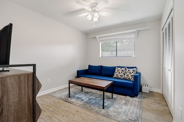 402 San Gabriel Blvd, Georgetown, TX 78628 - living area with wood finished floors, a ceiling fan, a textured ceiling, and baseboards