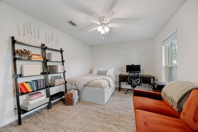 402 San Gabriel Blvd, Georgetown, TX 78628 - bedroom featuring wood finished floors, a desk, a textured ceiling, and ceiling fan