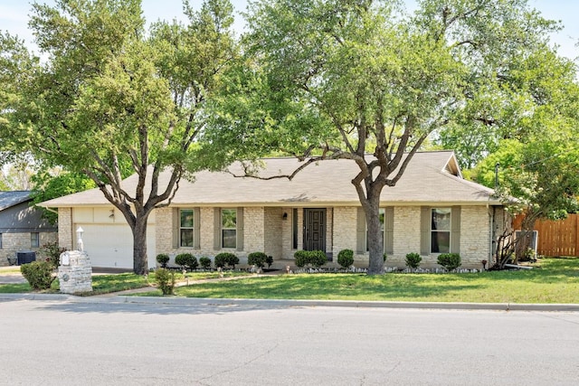 402 San Gabriel Blvd, Georgetown, TX 78628 - view of front of house featuring an attached garage, a front lawn, central AC unit, and brick siding