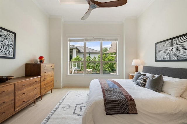bedroom with ornamental molding, a ceiling fan, and light wood-style floors