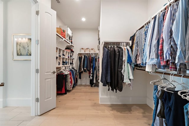 walk in closet with wood finished floors