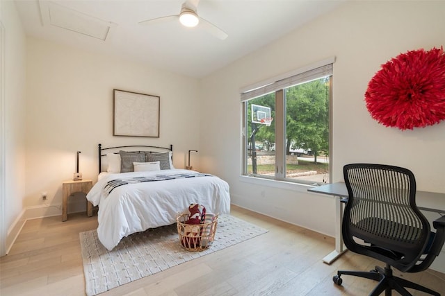 bedroom featuring attic access, a ceiling fan, light wood-style flooring, and baseboards