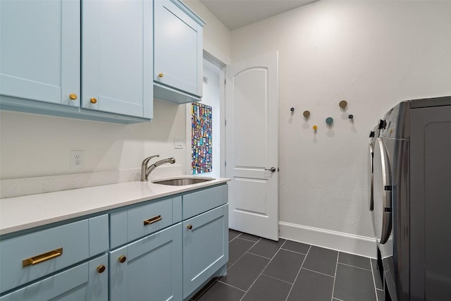 710 Crestone Stream Dr, Austin, TX 78738 - kitchen featuring dark tile patterned floors, light countertops, and blue cabinets