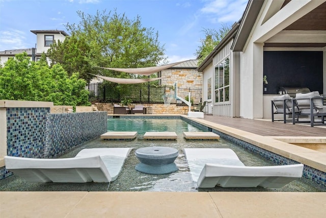 view of swimming pool featuring a deck, fence, and a pool with connected hot tub