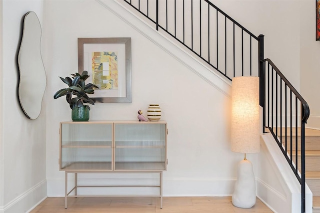 staircase featuring baseboards and wood finished floors