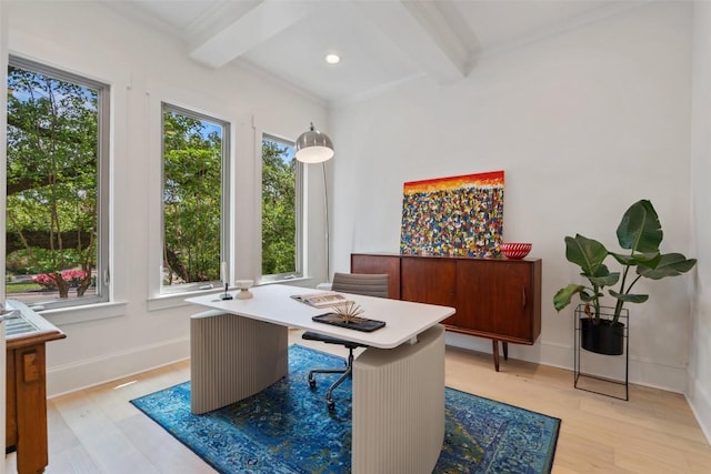 office space featuring baseboards, light wood-type flooring, beamed ceiling, and crown molding