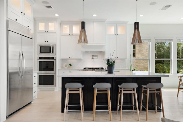 kitchen with recessed lighting, visible vents, white cabinets, and built in appliances