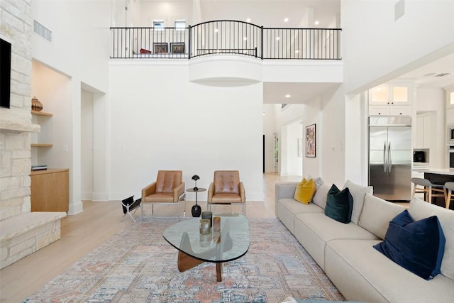 710 Crestone Stream Dr, Austin, TX 78738 - living room with a high ceiling, light wood finished floors, and a fireplace