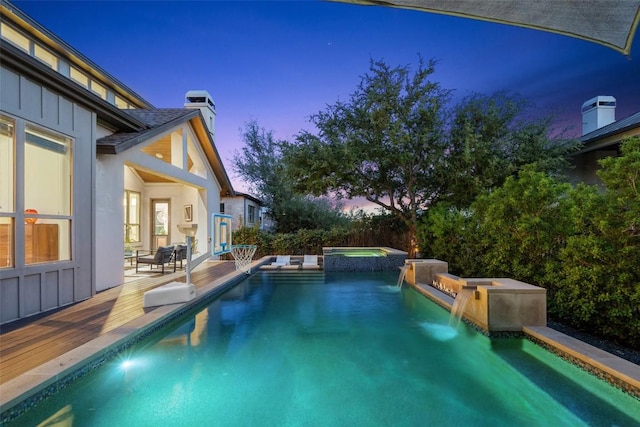 view of swimming pool with a deck and a pool with connected hot tub