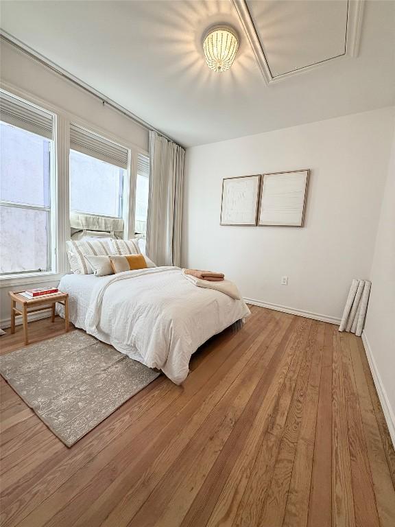 1018 Shelley Ave, Austin, TX 78703 - bedroom with wood finished floors, baseboards, and attic access