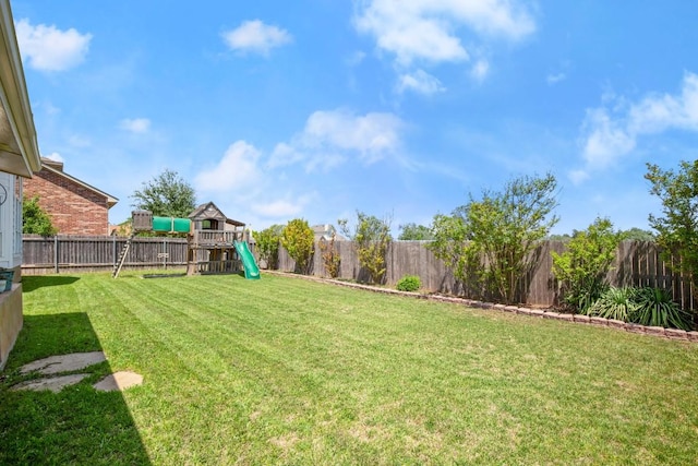 view of yard featuring a fenced backyard and a playground