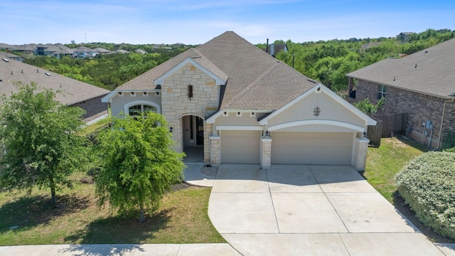 200 S Sage Holw, Dripping Springs, TX 78620 - view of front of home with roof with shingles, driveway, stone siding, a garage, and stucco siding