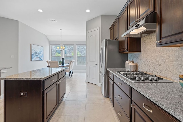 200 S Sage Holw, Dripping Springs, TX 78620 - kitchen with dark brown cabinets, decorative backsplash, an inviting chandelier, under cabinet range hood, and visible vents