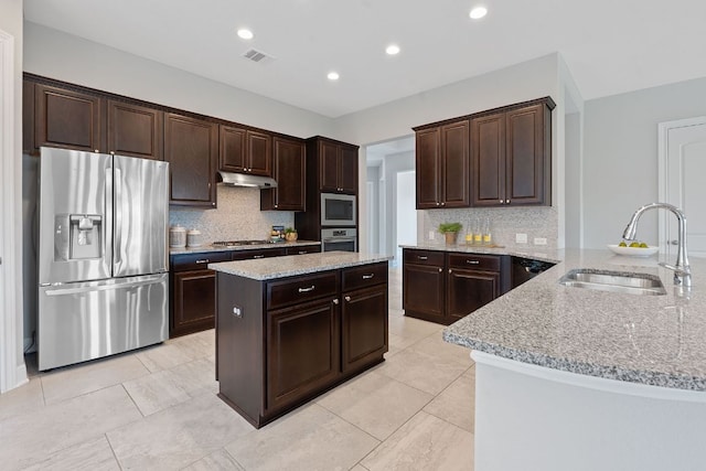 200 S Sage Holw, Dripping Springs, TX 78620 - kitchen with stainless steel appliances, a sink, visible vents, light stone countertops, and under cabinet range hood