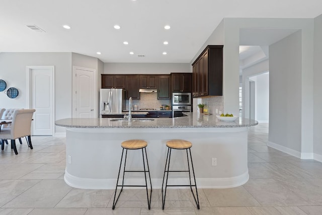 200 S Sage Holw, Dripping Springs, TX 78620 - kitchen featuring dark brown cabinetry, stainless steel appliances, a sink, and light stone counters