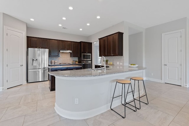 200 S Sage Holw, Dripping Springs, TX 78620 - kitchen featuring a sink, dark brown cabinetry, decorative backsplash, under cabinet range hood, and appliances with stainless steel finishes