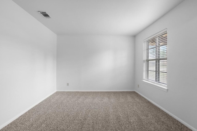 carpeted empty room featuring visible vents and baseboards