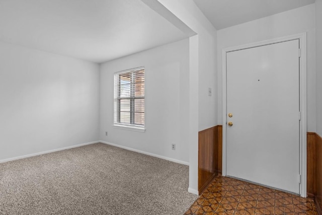 carpeted foyer entrance featuring baseboards