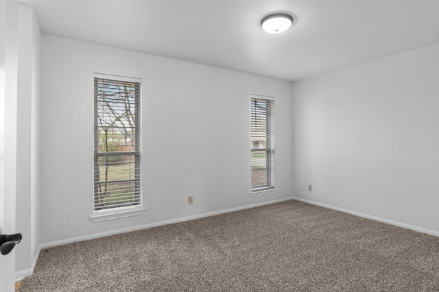 carpeted spare room with baseboards