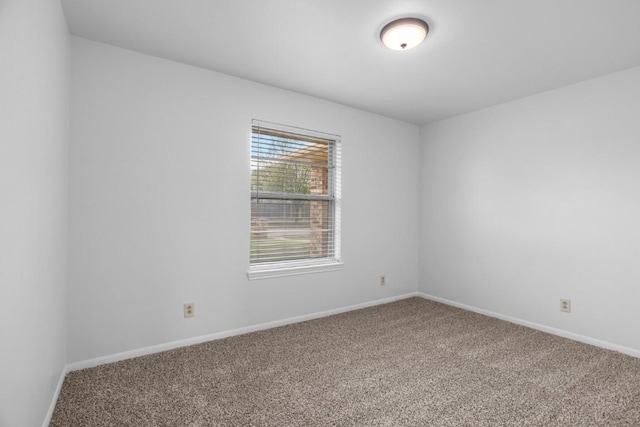 empty room with baseboards and carpet