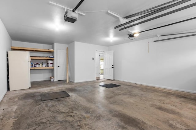 garage featuring freestanding refrigerator and a garage door opener