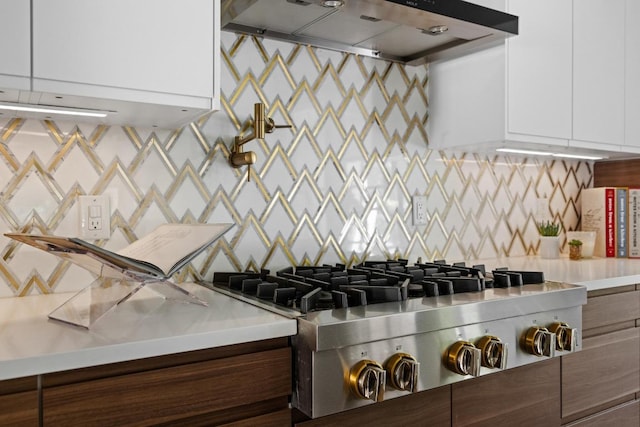 6103 Twin Ledge Dr, Austin, TX 78731 - kitchen with under cabinet range hood, stainless steel gas cooktop, modern cabinets, light countertops, and backsplash
