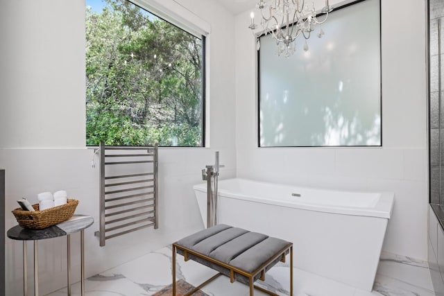 6103 Twin Ledge Dr, Austin, TX 78731 - bathroom with marble finish floors, tile walls, a freestanding tub, plenty of natural light, and a chandelier