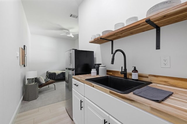 6103 Twin Ledge Dr, Austin, TX 78731 - kitchen with open shelves, freestanding refrigerator, wooden counters, white cabinets, and a ceiling fan