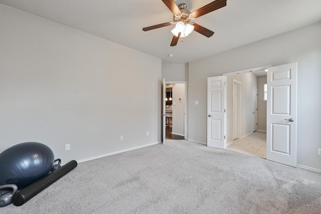 unfurnished bedroom with light colored carpet, baseboards, and a ceiling fan