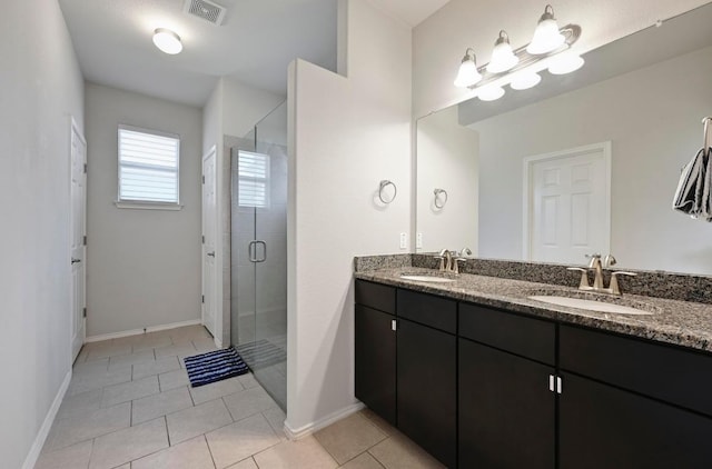 full bath with double vanity, a shower stall, visible vents, and a sink