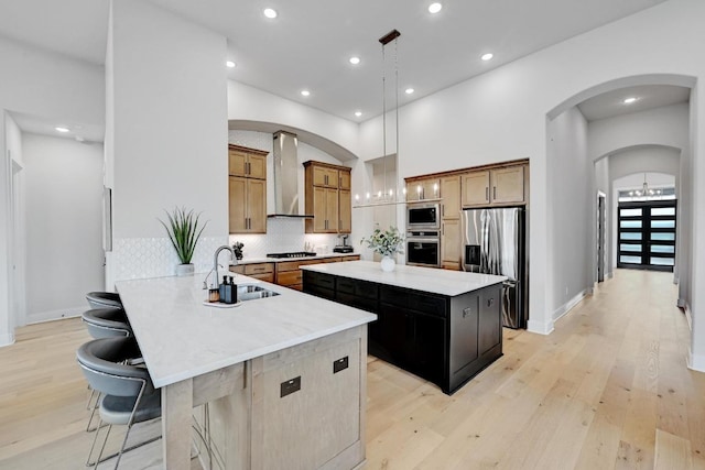 422 Quiet Oak Rd, San Marcos, TX 78666 - kitchen with stainless steel appliances, a sink, wall chimney range hood, light countertops, and a kitchen island