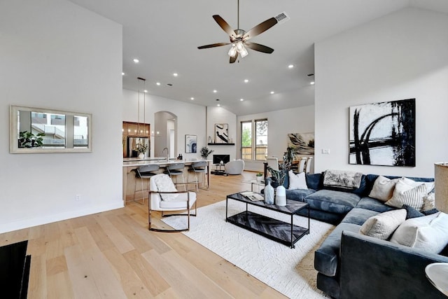422 Quiet Oak Rd, San Marcos, TX 78666 - living area with light wood finished floors, arched walkways, visible vents, lofted ceiling, and a ceiling fan
