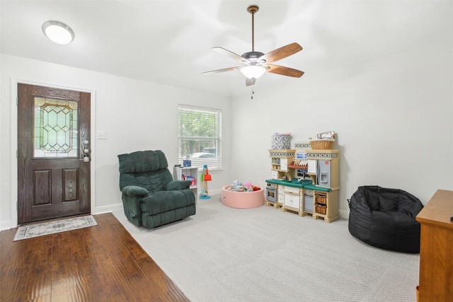 playroom featuring baseboards, a ceiling fan, and wood finished floors