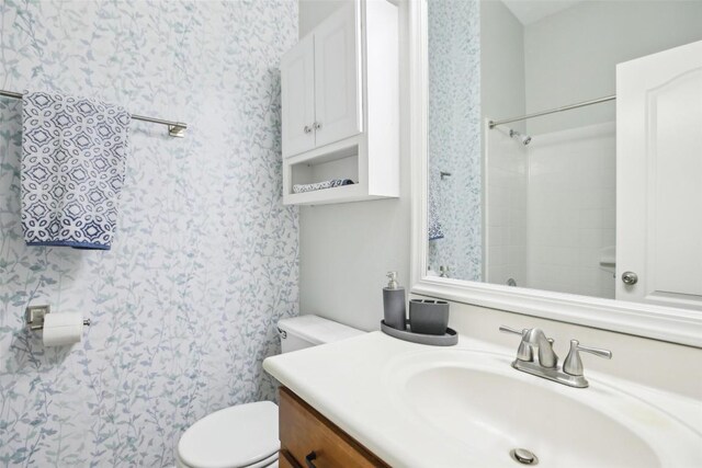 full bath with a shower, toilet, vanity, and wallpapered walls