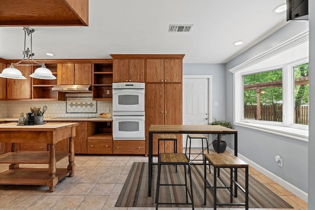 kitchen with tasteful backsplash, open shelves, white double oven, under cabinet range hood, and visible vents