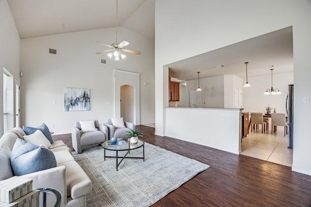 4001 Veiled Falls Dr, Pflugerville, TX 78660 - living room featuring arched walkways, ceiling fan, light wood-style flooring, a chandelier, and high vaulted ceiling