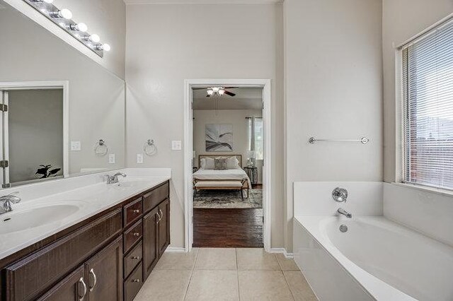 4001 Veiled Falls Dr, Pflugerville, TX 78660 - ensuite bathroom featuring double vanity, tile patterned floors, a bath, baseboards, and ceiling fan