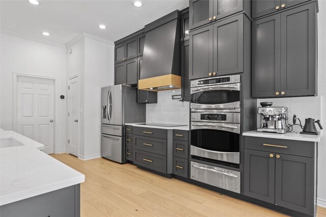 20 Hedgebrook Way, The Hills, TX 78738 - kitchen featuring a warming drawer, appliances with stainless steel finishes, premium range hood, light wood-style floors, and light countertops