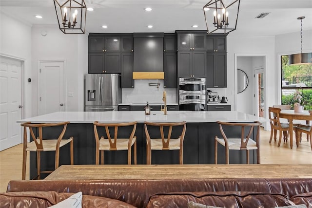 20 Hedgebrook Way, The Hills, TX 78738 - kitchen featuring stainless steel appliances, a chandelier, light wood-type flooring, light countertops, and recessed lighting