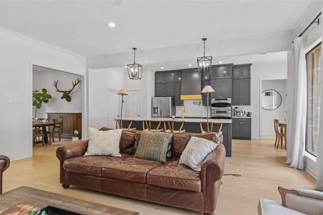 20 Hedgebrook Way, The Hills, TX 78738 - living room with light wood finished floors, crown molding, recessed lighting, and a chandelier