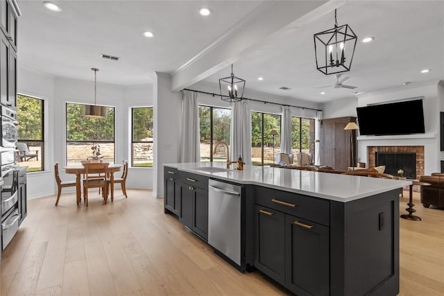 20 Hedgebrook Way, The Hills, TX 78738 - kitchen featuring stainless steel dishwasher, light countertops, crown molding, pendant lighting, and a fireplace