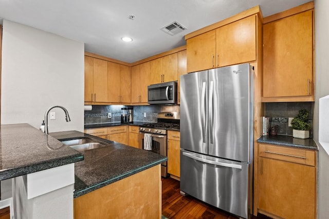 503 Swanee Dr Unit 11, Austin, TX 78752 - kitchen featuring appliances with stainless steel finishes, a peninsula, dark wood-style floors, tasteful backsplash, and recessed lighting