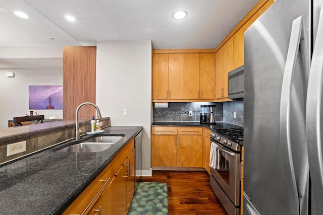 503 Swanee Dr Unit 11, Austin, TX 78752 - kitchen featuring appliances with stainless steel finishes, dark wood-style flooring, dark stone countertops, recessed lighting, and tasteful backsplash