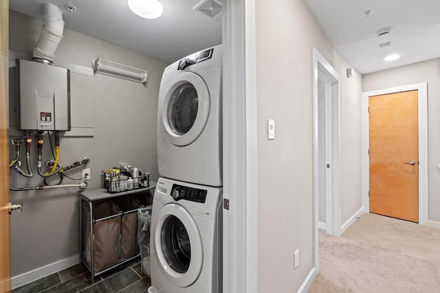 503 Swanee Dr Unit 11, Austin, TX 78752 - laundry area with stacked washer and clothes dryer, water heater, and carpet flooring