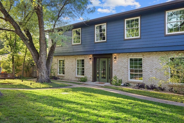colonial home featuring brick siding and a front yard